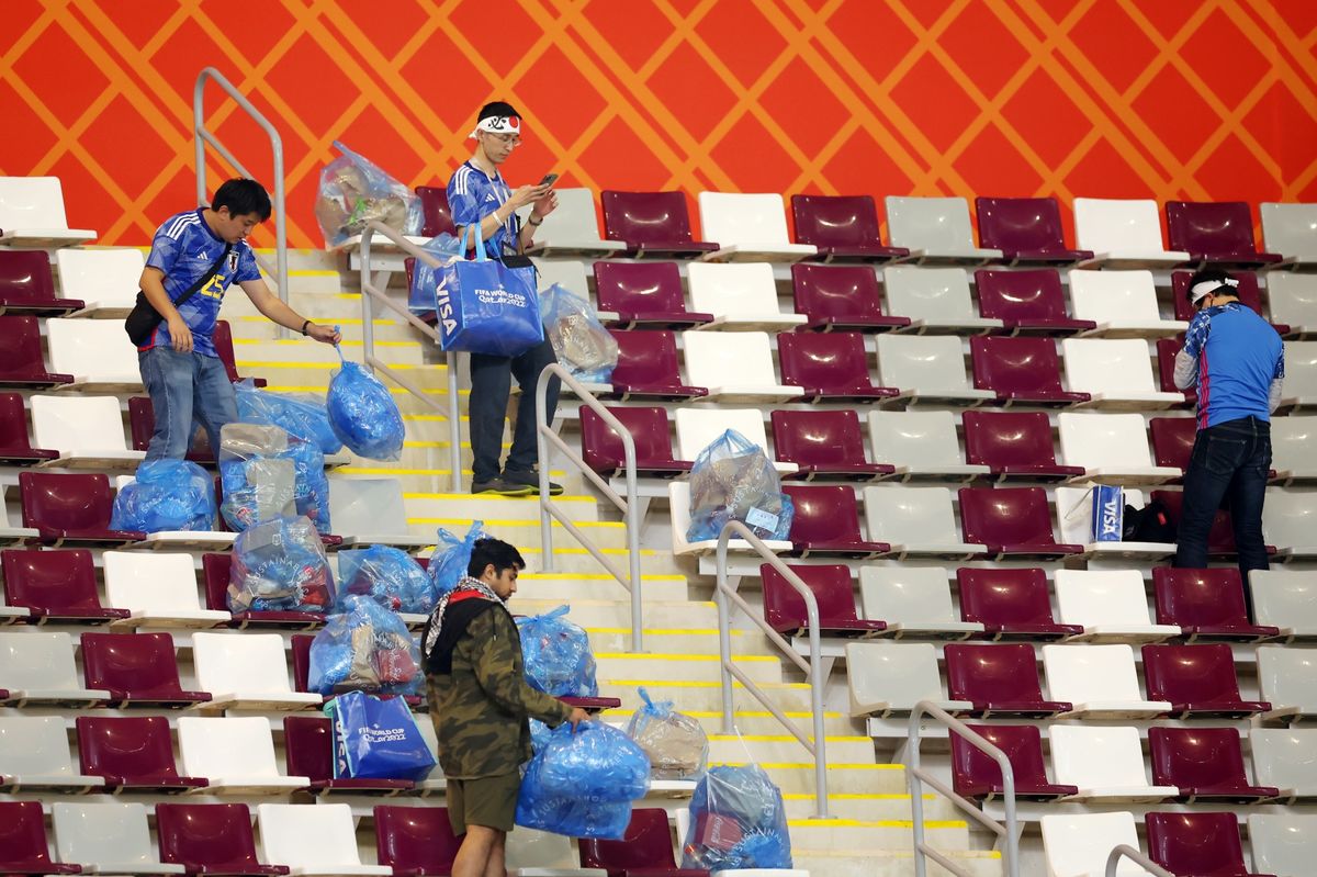 Japanese fans cleaning up a seating section following a world cup game